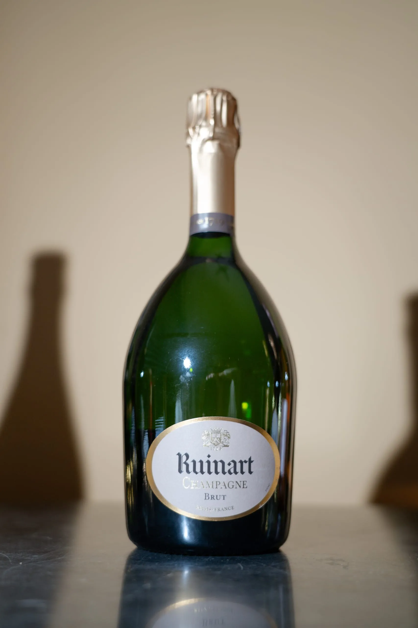 Bouteille de champagne Ruinart Brut posée sur un comptoir