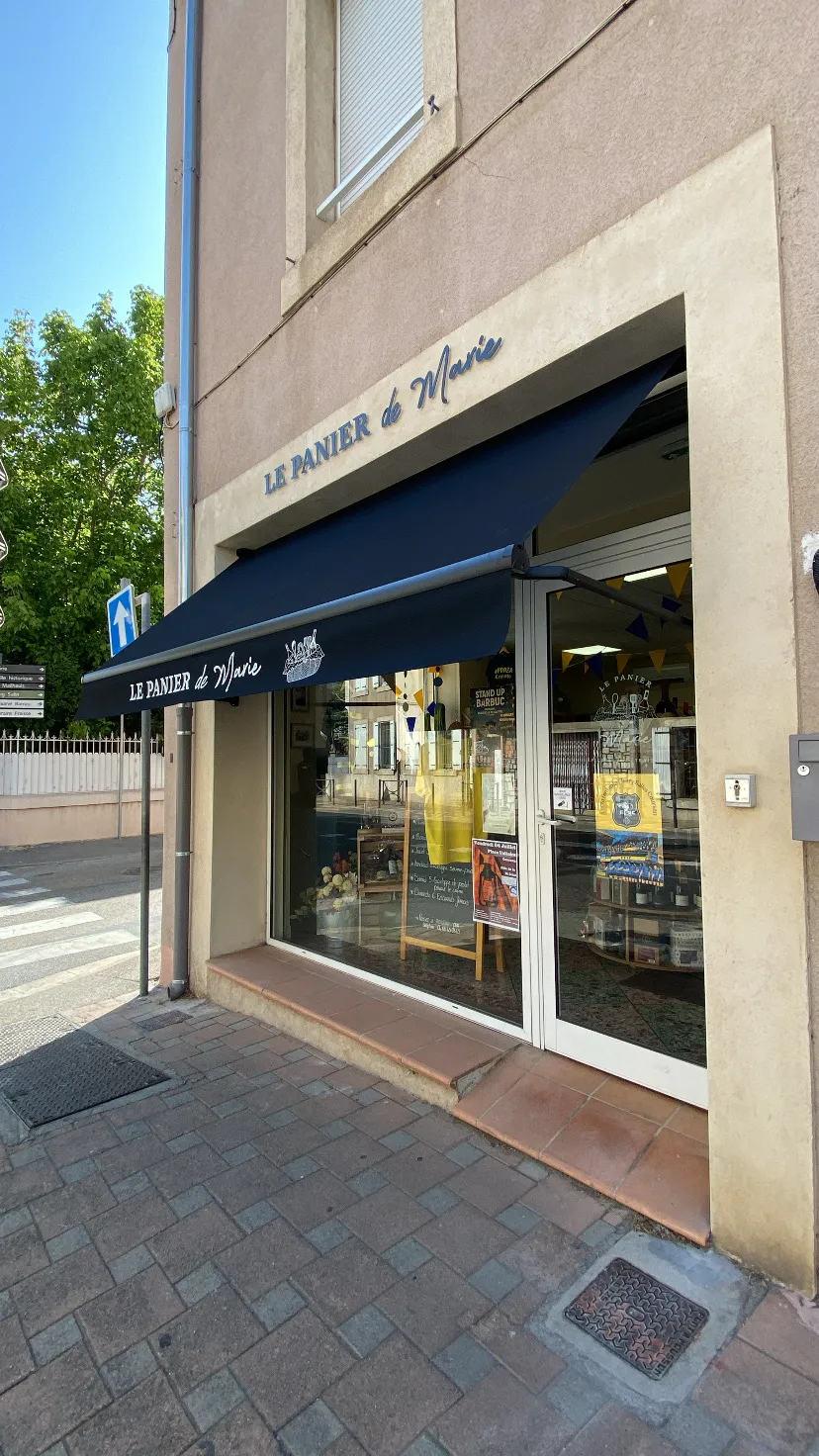 Façade de la boutique Le Panier de Marie avec son enseigne, son store bleu et sa vitrine