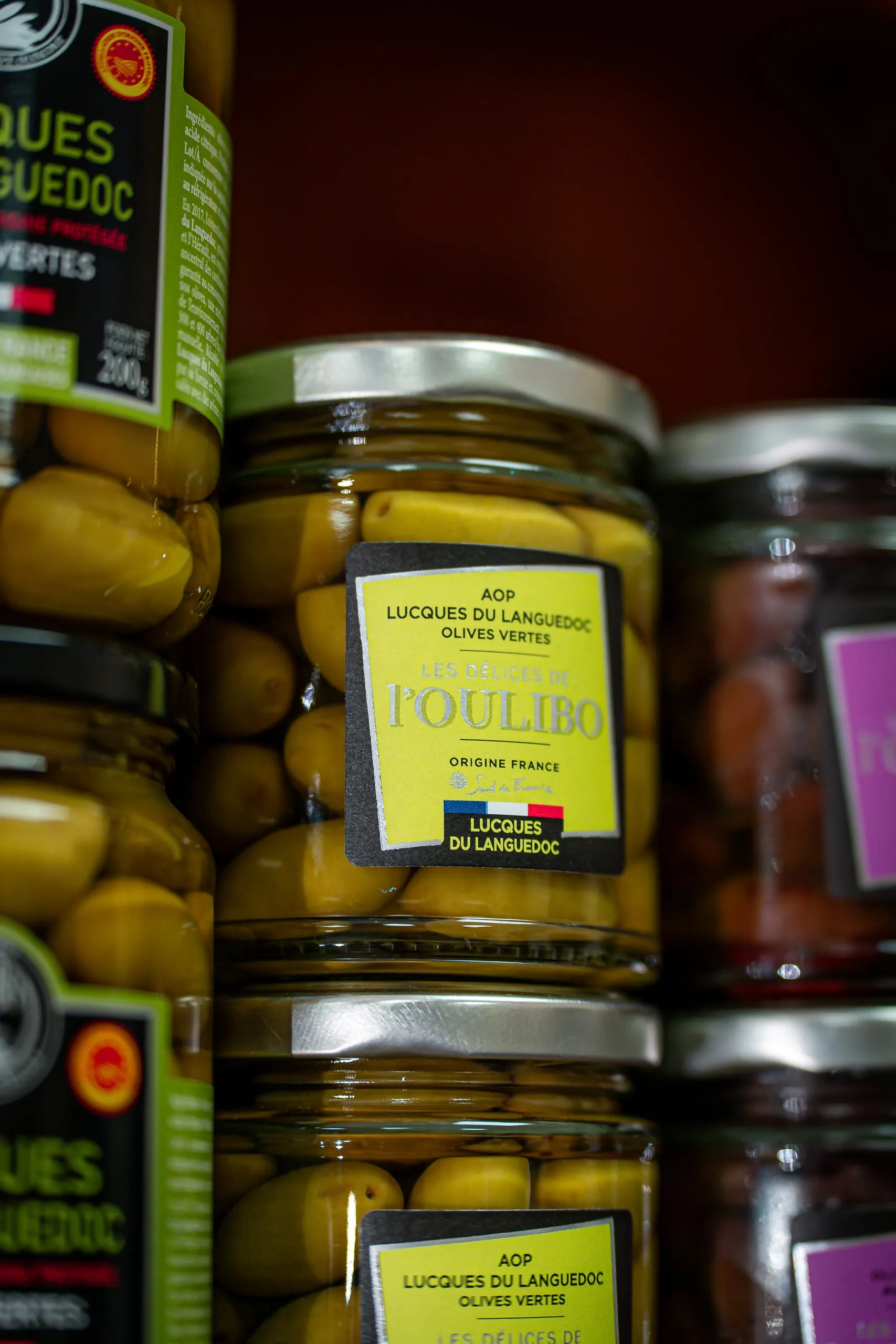 Bocaux d’olives vertes lucques du Languedoc alignés sur une étagère