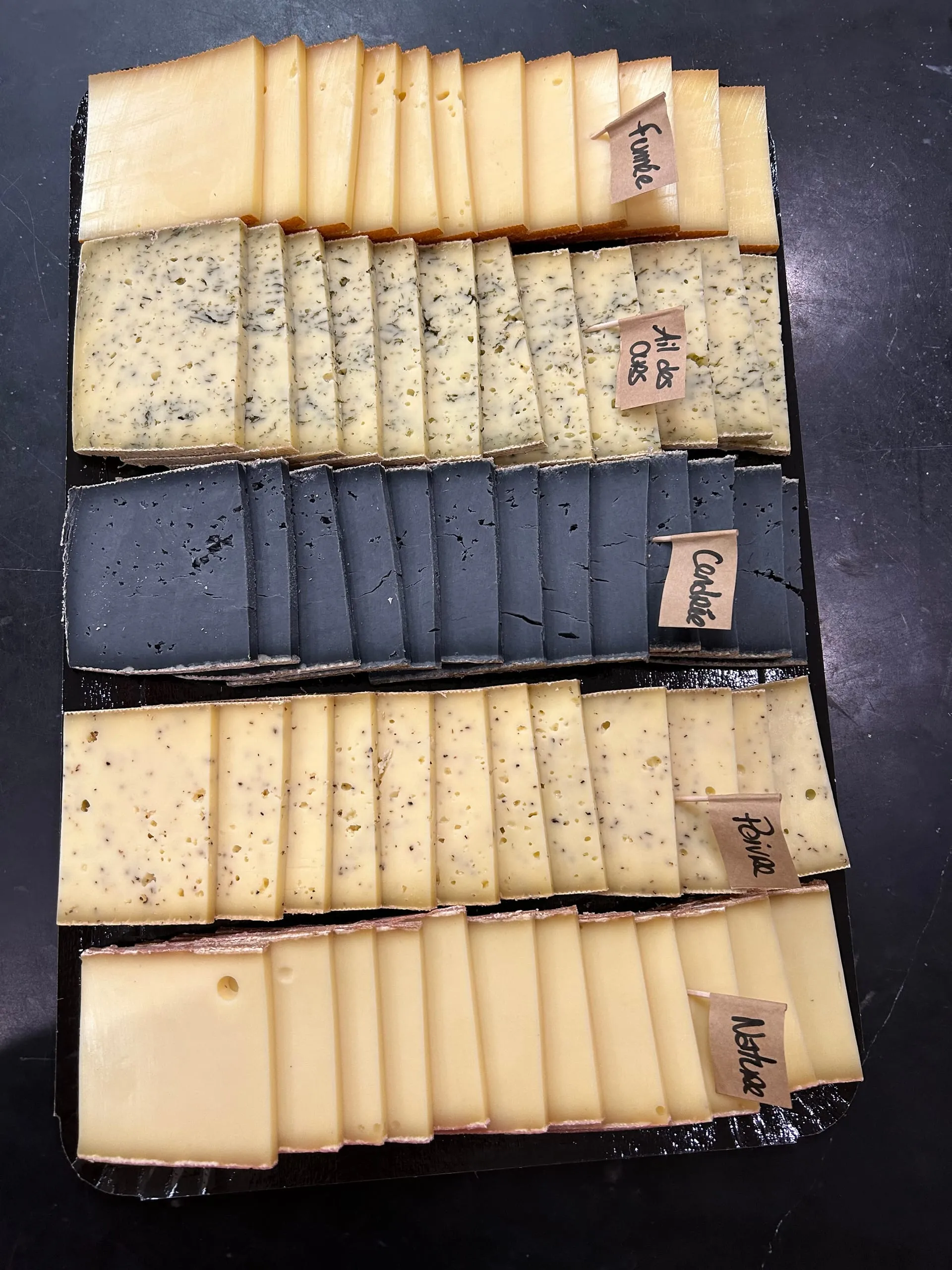 Plateau de fromages tranchés aux différentes saveurs disposés en rangées