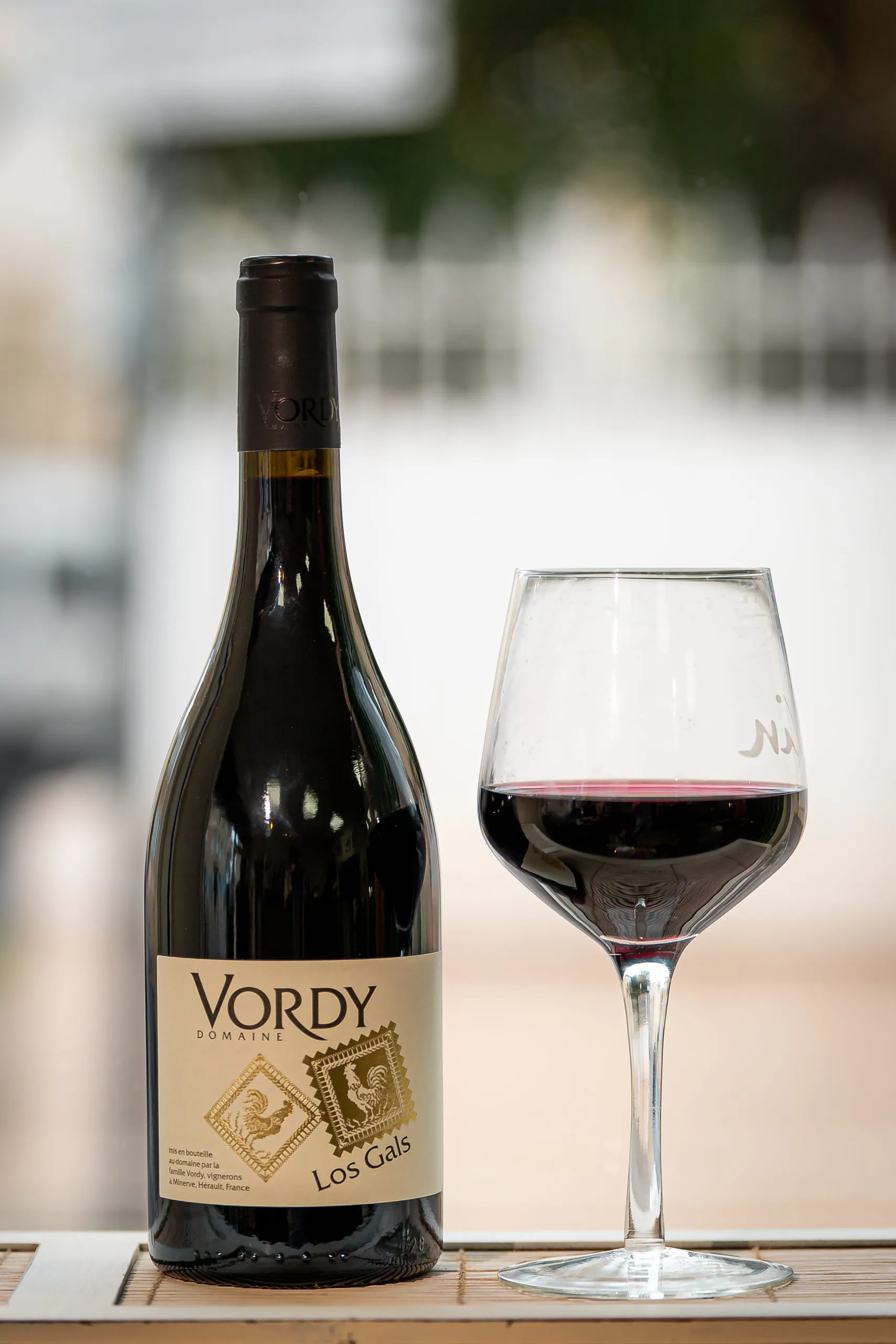 Bouteille de vin rouge placée à côté d’un verre servi